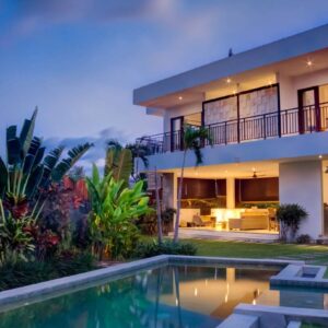 A large white house with a pool in the middle of it.